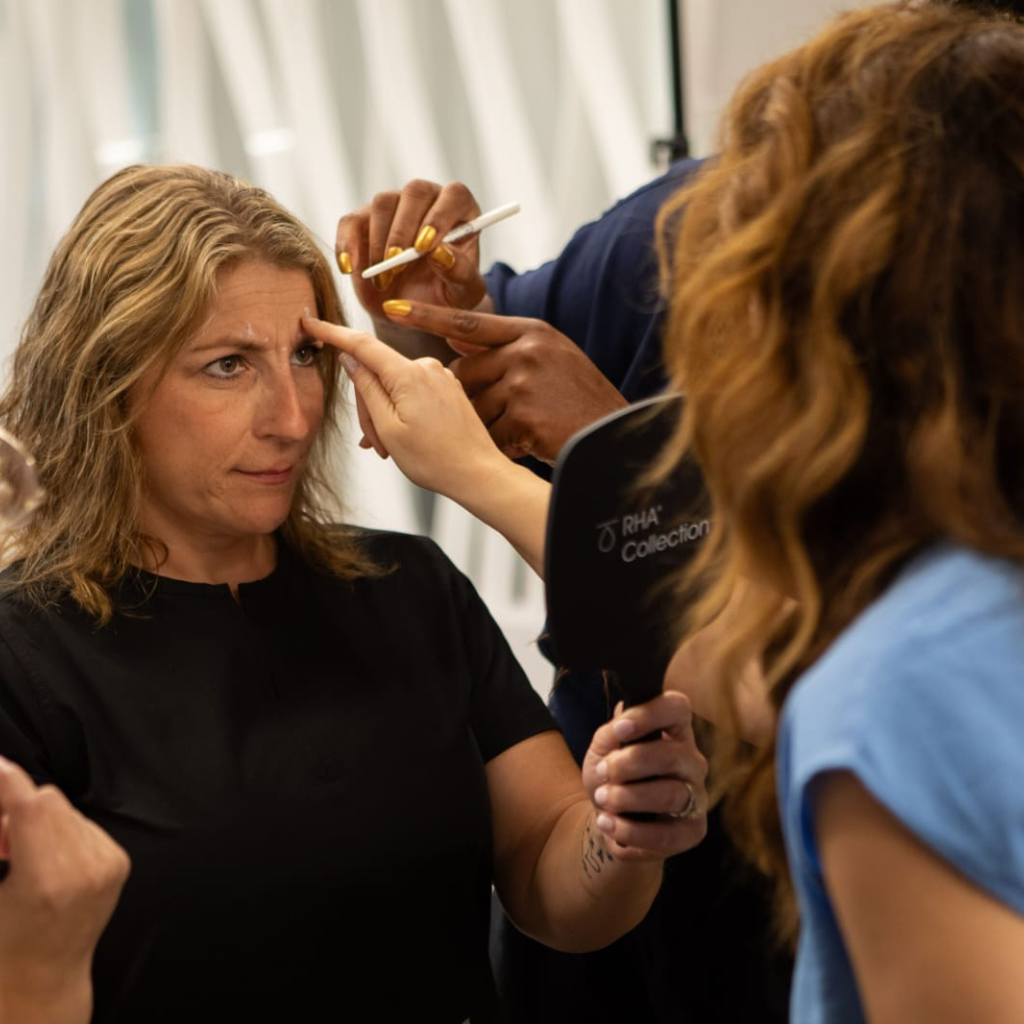 Aesthetic professionals assessing a client's facial features before treatment