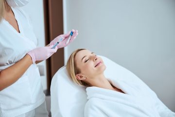 Aesthetic treatment being administered to a woman lying on a treatment bed.
